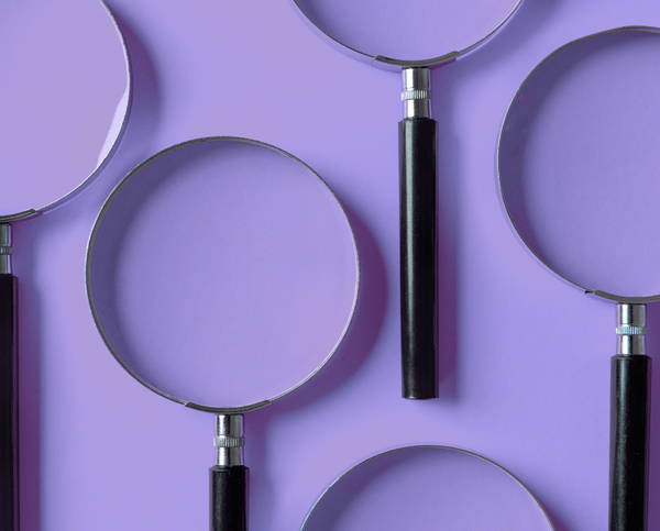 Several magnifying glasses arranged on a purple background