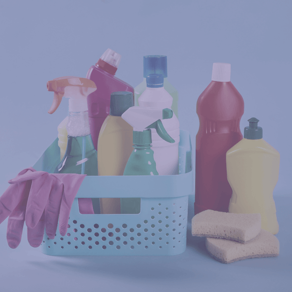 Basket of household cleaning products, gloves and sponges in a blue-tinted photo