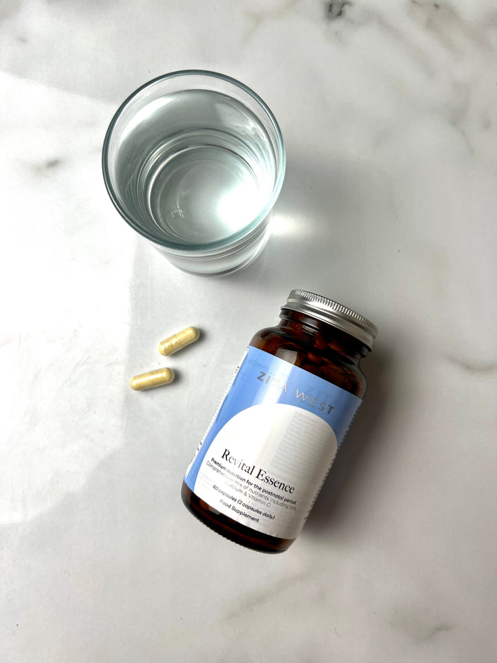 Zita West Revital Essence supplement bottle with capsules and a glass of water