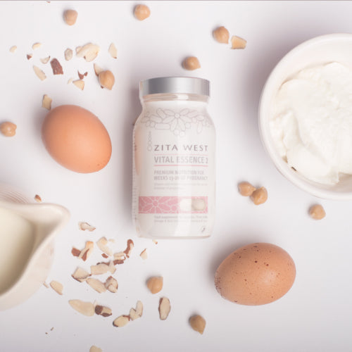 Bottle of Zita West Vital Essence 2 supplement surrounded by eggs, cream and chopped nuts