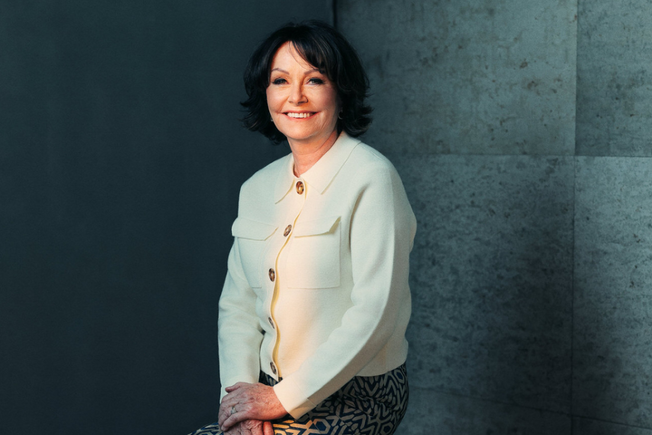 Portrait of a smiling woman in a cream jacket for a free webinar