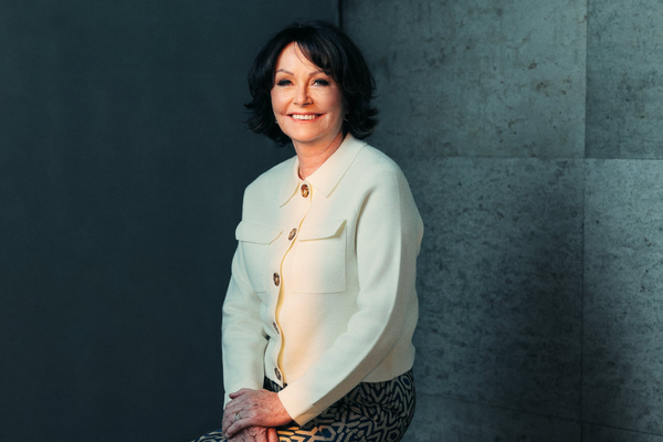 Portrait of a smiling woman in a cream jacket for a free webinar
