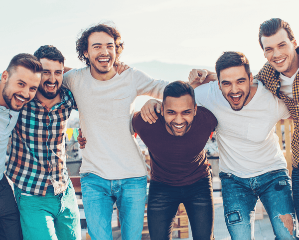Group of six men laughing together with arms around each other