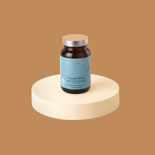 Zita West Vitamen Boost supplement bottle displayed on a pedestal against a tan background