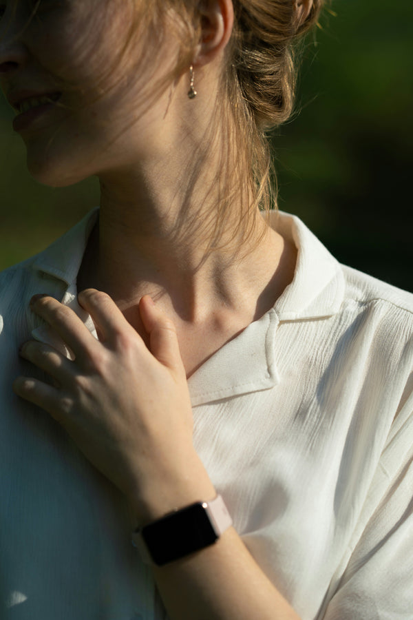 Close-up of a woman's neck with her hand resting near her throat