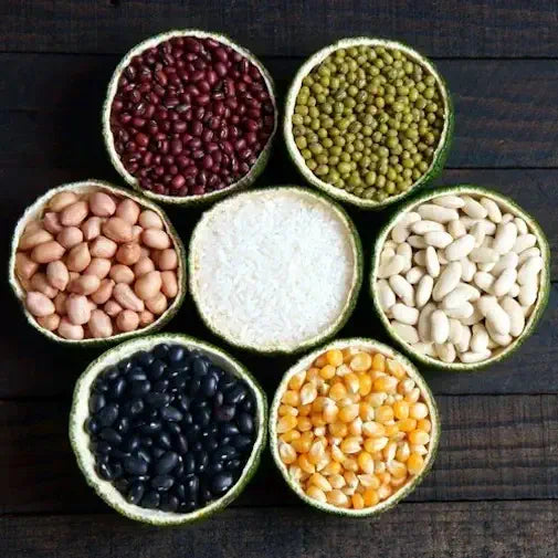 Bowls of beans, rice and grains arranged in a flower pattern on a wooden table