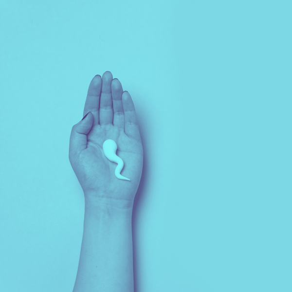 Hand holding a single white sperm-shaped clay figure against a blue background