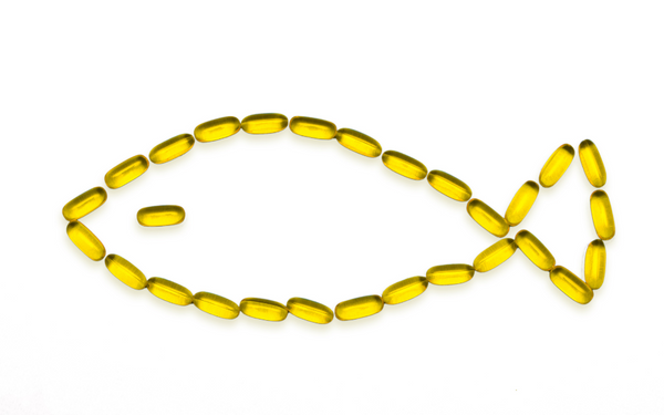 Omega-3 fish oil capsules arranged in the shape of a fish