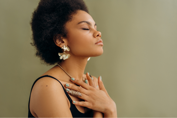 Woman with eyes closed holding her hand to her chest in a calm pose