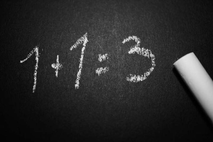 Handwritten chalkboard equation reading '1+1=3' with a piece of chalk