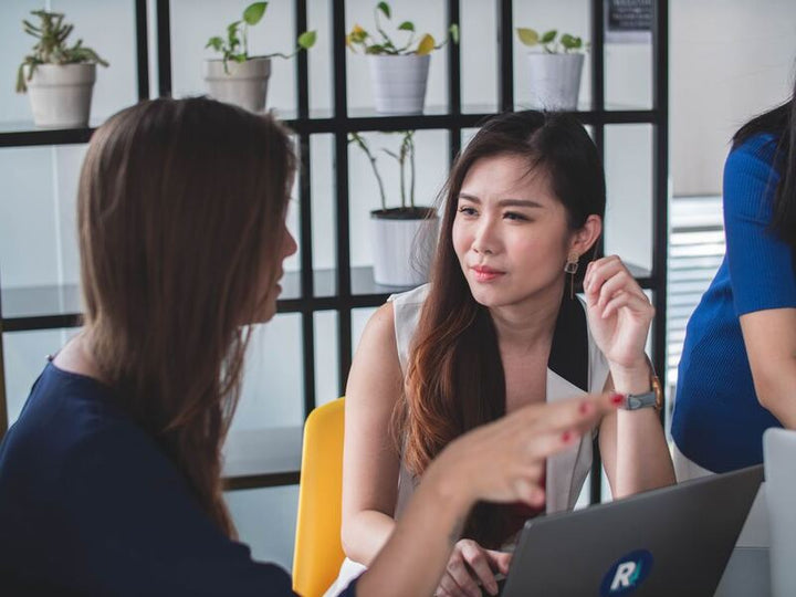 Two women in a business meeting talking beside a laptop