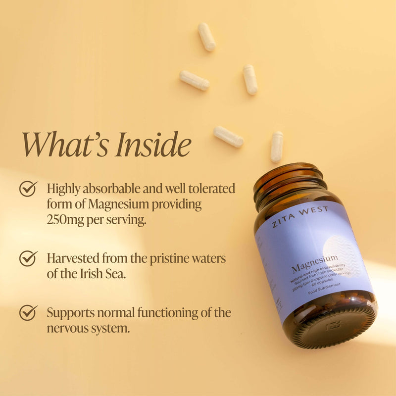 An open bottle of Zita West Magnesium with capsules scattered on a yellow background