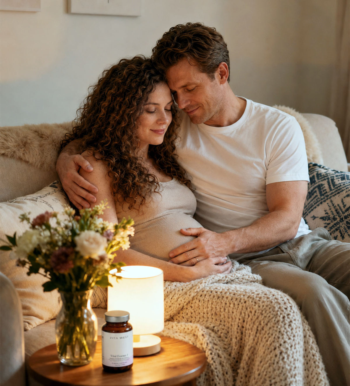 A pregnant woman sat with her partner. Zita West supplements in the foreground